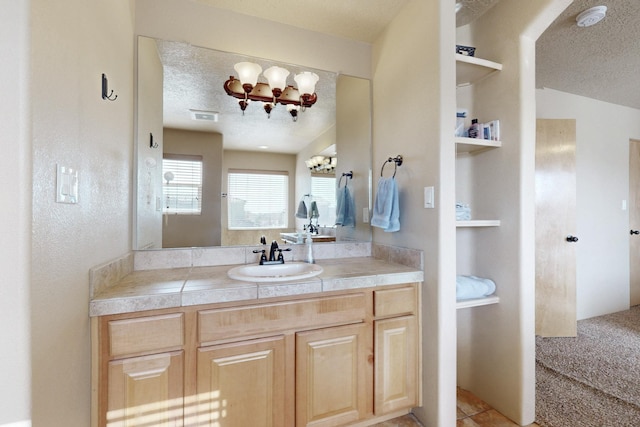 bathroom featuring a textured ceiling, vanity, and visible vents