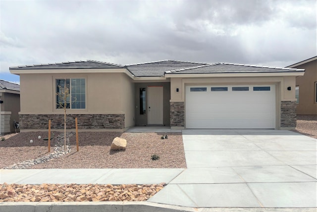 view of front of property with stone siding, an attached garage, and driveway