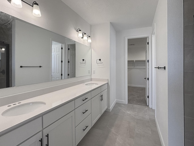 3340 Wolf Tail Loop NE, Rio Rancho, NM 87144 - full bath with double vanity, a spacious closet, and a textured ceiling
