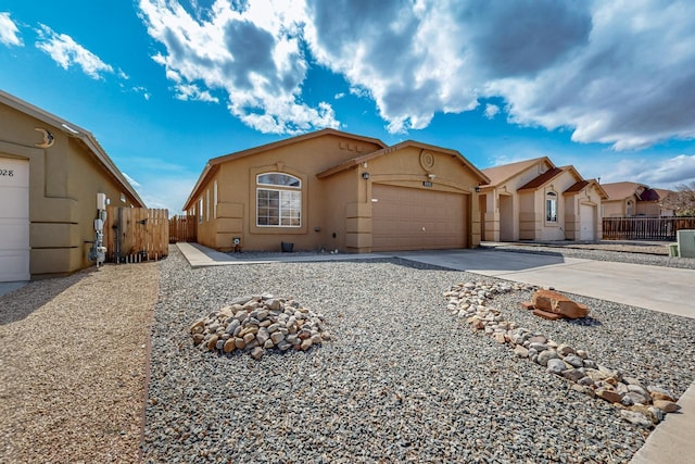 view of front of home with a garage, fence, concrete driveway, a gate, and stucco siding