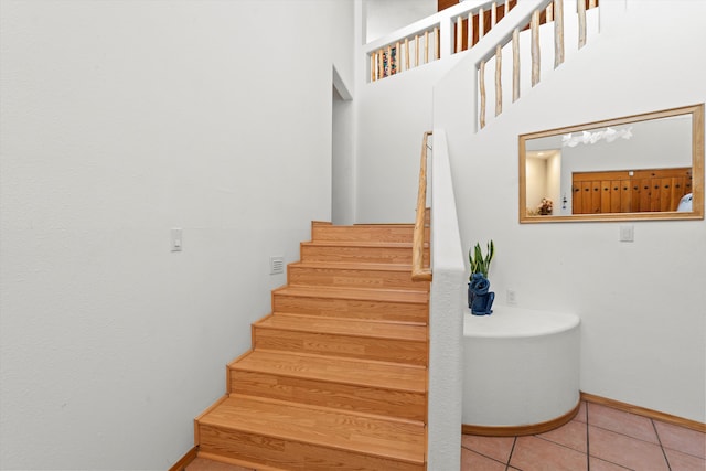 stairway featuring tile patterned flooring and baseboards