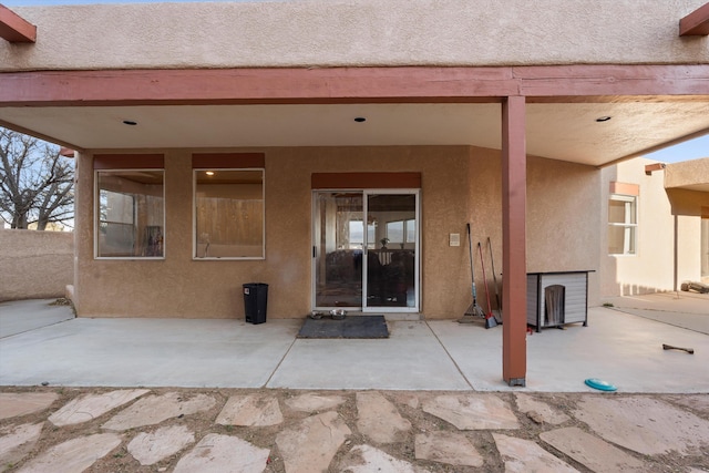 entrance to property featuring a patio and stucco siding