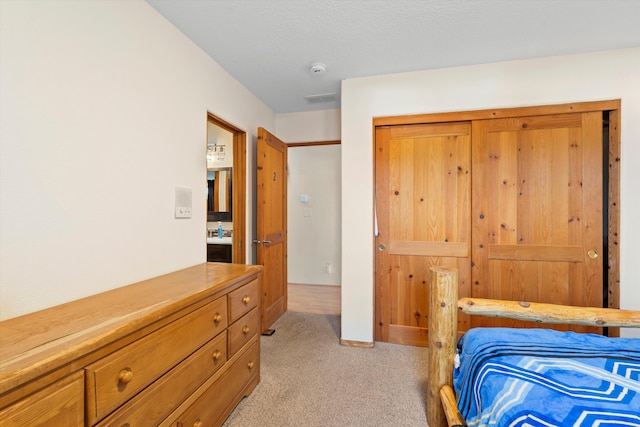 bedroom featuring a closet and light colored carpet