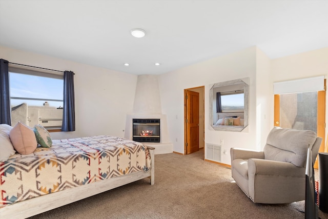 carpeted bedroom featuring recessed lighting, a large fireplace, visible vents, and baseboards