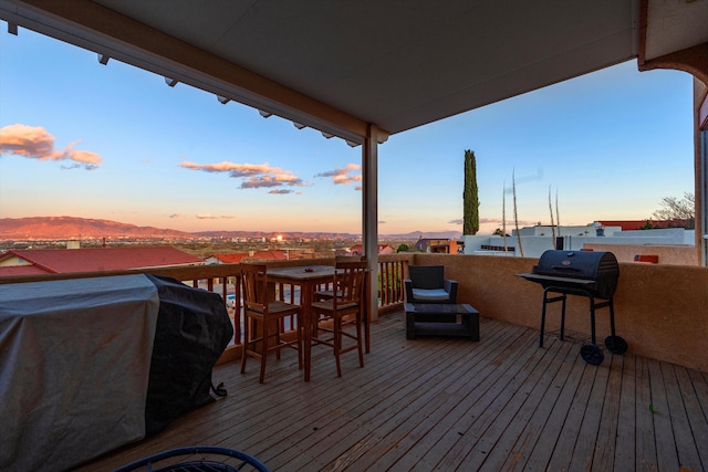 deck at dusk featuring grilling area