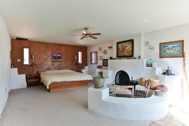 627 Fairway Rd NW, Albuquerque, NM 87107 - carpeted bedroom with wood walls, ceiling fan, and a fireplace with raised hearth