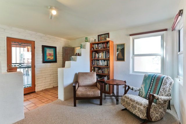 627 Fairway Rd NW, Albuquerque, NM 87107 - living area with tile patterned flooring, carpet floors, and brick wall