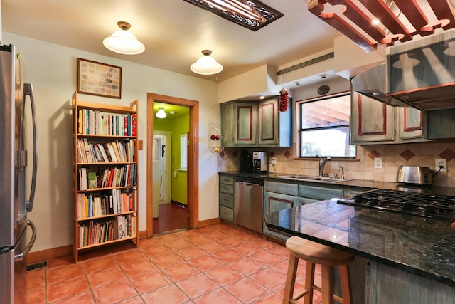 627 Fairway Rd NW, Albuquerque, NM 87107 - kitchen featuring stainless steel appliances, backsplash, light tile patterned floors, and a kitchen bar