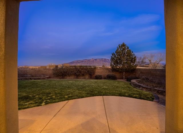 exterior space with a patio, a fenced backyard, and a mountain view