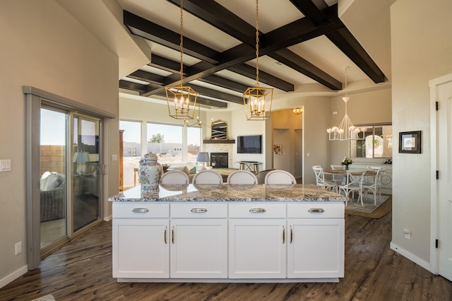 kitchen featuring dark wood-style floors, baseboards, white cabinetry, and a notable chandelier