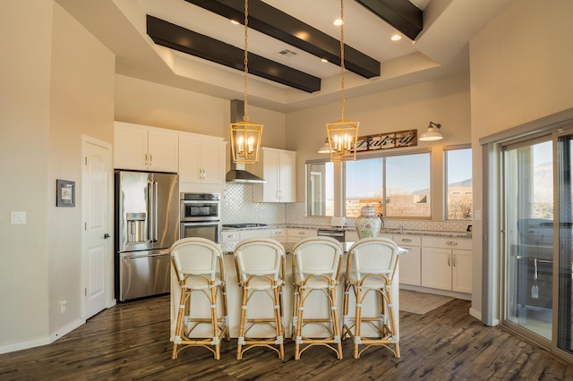 kitchen with dark wood finished floors, tasteful backsplash, a towering ceiling, appliances with stainless steel finishes, and beamed ceiling