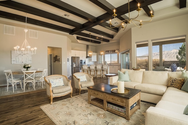 living room with an inviting chandelier, beam ceiling, visible vents, and wood finished floors