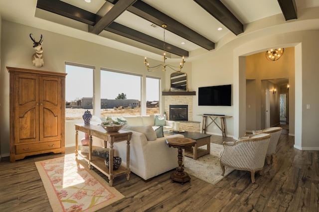 living area featuring baseboards, dark wood finished floors, beamed ceiling, an inviting chandelier, and a fireplace