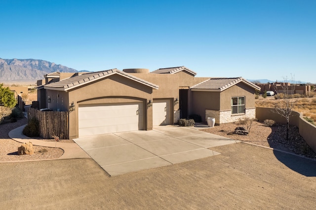 view of front of home featuring a garage, stone siding, concrete driveway, and stucco siding