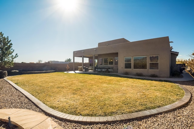 back of house featuring a yard, a patio, fence, and stucco siding