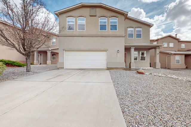 view of front of house with concrete driveway, a garage, and stucco siding