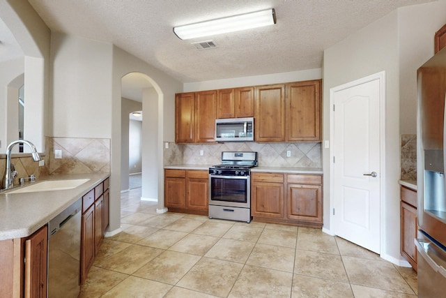 kitchen featuring visible vents, stainless steel appliances, light countertops, and a sink