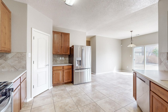 kitchen with stainless steel appliances, brown cabinetry, and light countertops