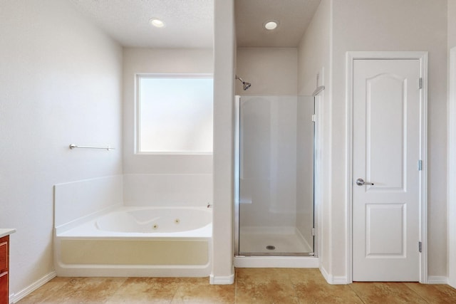 full bathroom with a stall shower, a tub with jets, tile patterned flooring, baseboards, and vanity