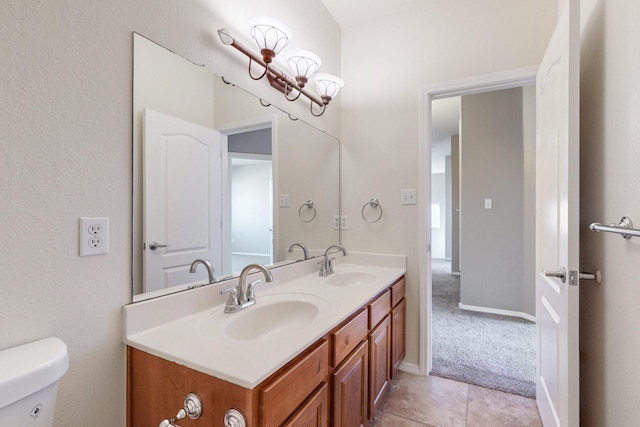 bathroom featuring double vanity, tile patterned floors, toilet, and a sink