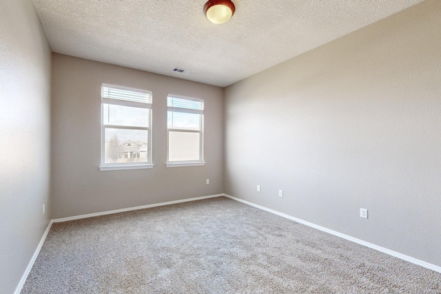 unfurnished room featuring visible vents, baseboards, a textured ceiling, and carpet flooring