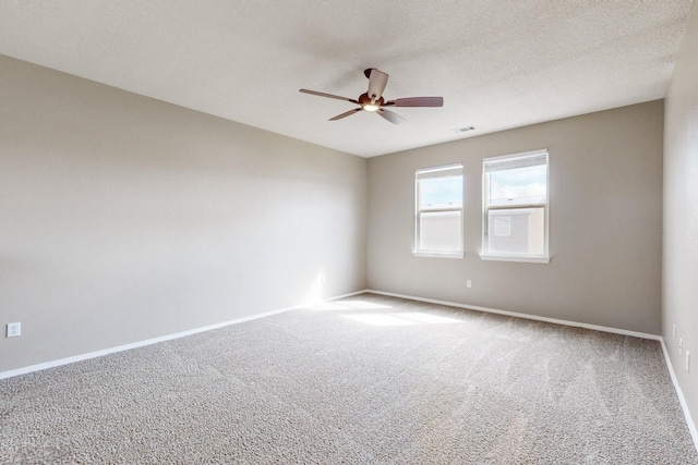 empty room with a ceiling fan, visible vents, baseboards, a textured ceiling, and carpet flooring