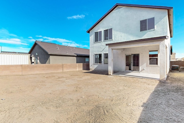 rear view of house with a patio, a fenced backyard, central AC, and stucco siding