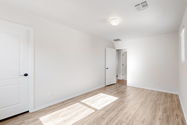 empty room featuring visible vents, baseboards, and light wood-style floors