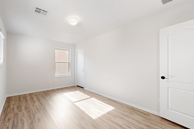 empty room with visible vents, baseboards, and light wood-style flooring