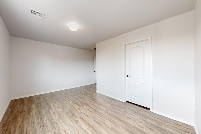 empty room with visible vents, baseboards, and light wood finished floors