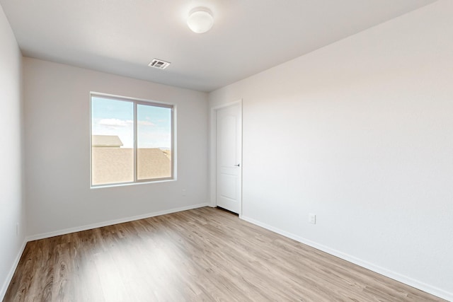 empty room with visible vents, baseboards, and light wood-type flooring