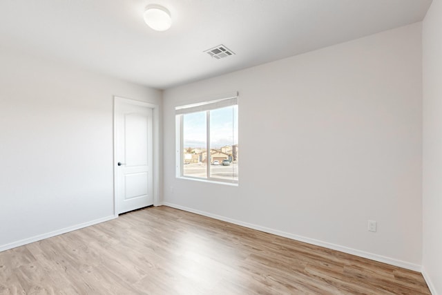 unfurnished room featuring light wood-style flooring, baseboards, and visible vents