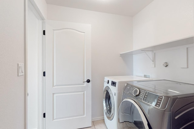 laundry area with washer and dryer, laundry area, and light tile patterned floors