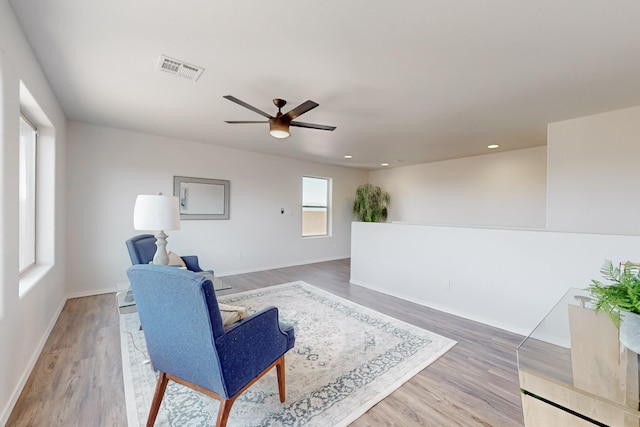 sitting room with light wood-style flooring, baseboards, and visible vents