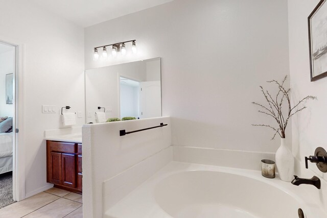 ensuite bathroom with tile patterned floors, ensuite bath, vanity, and a bath