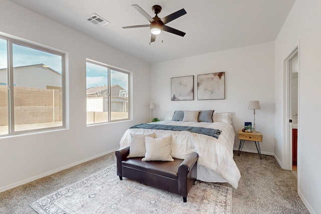 bedroom with visible vents, light colored carpet, and baseboards