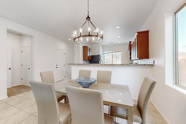 dining room with light tile patterned flooring, recessed lighting, baseboards, and a chandelier