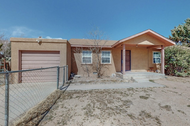 view of front of house with an attached garage, fence, and stucco siding