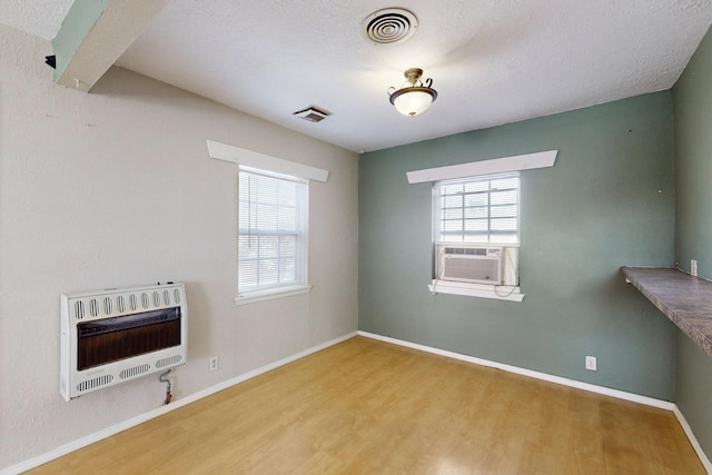 unfurnished living room featuring cooling unit, a healthy amount of sunlight, visible vents, and heating unit