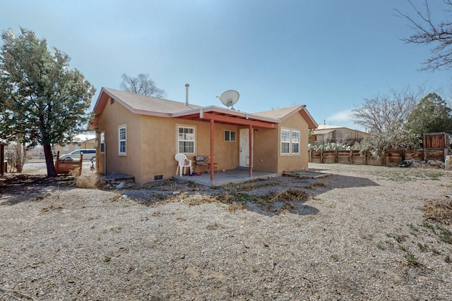 back of house with crawl space, a patio area, fence, and stucco siding