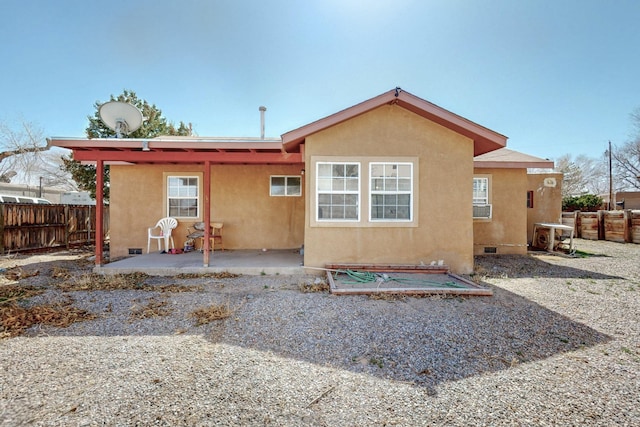 back of house featuring crawl space, a patio area, fence, and stucco siding