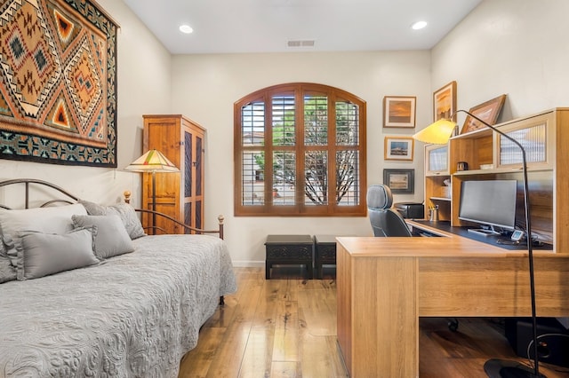 bedroom with wood-type flooring, visible vents, baseboards, and recessed lighting