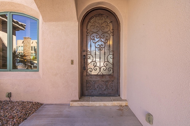 doorway to property featuring stucco siding