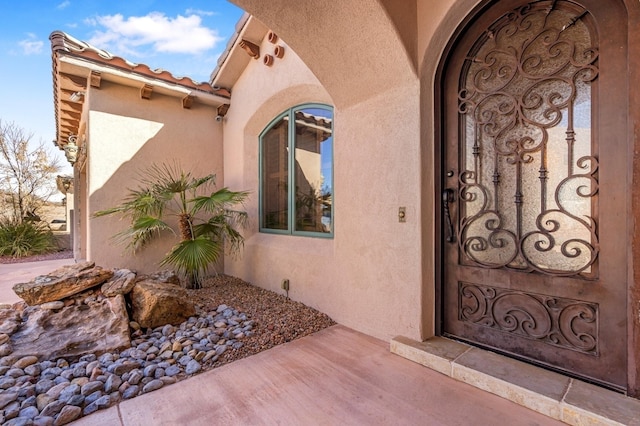 doorway to property with a tiled roof and stucco siding