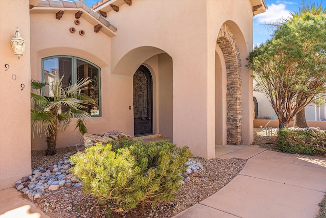 property entrance with a tiled roof and stucco siding