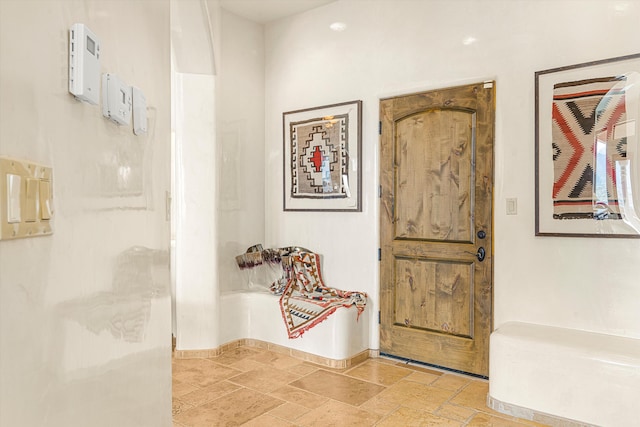 interior space featuring baseboards and stone tile floors