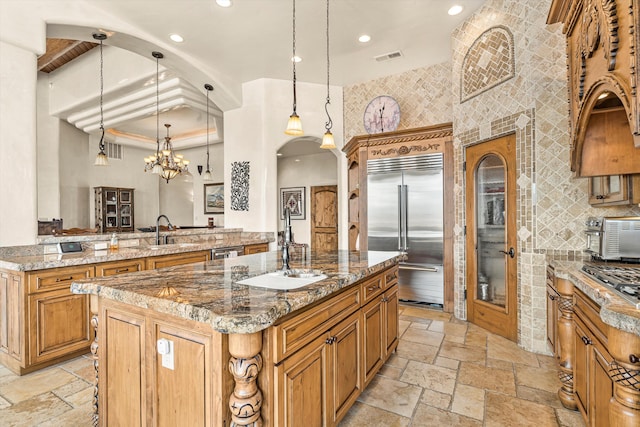 kitchen featuring stone tile floors, a kitchen island, appliances with stainless steel finishes, light stone countertops, and recessed lighting