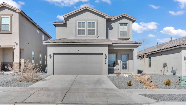 view of front of home featuring a tiled roof, stucco siding, an attached garage, and driveway