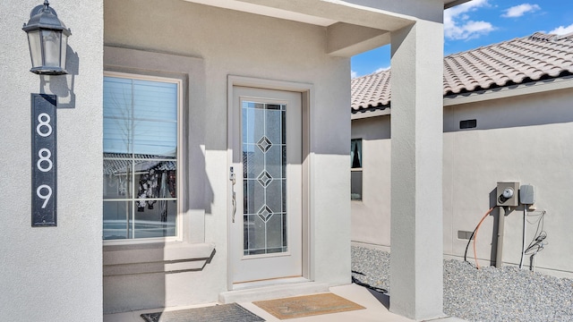 property entrance featuring stucco siding and a tile roof