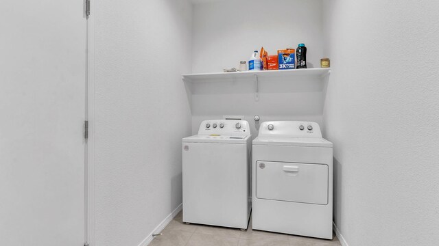 889 Tazanita Loop SE, Rio Rancho, NM 87124 - laundry room featuring washer and clothes dryer, baseboards, and light tile patterned flooring